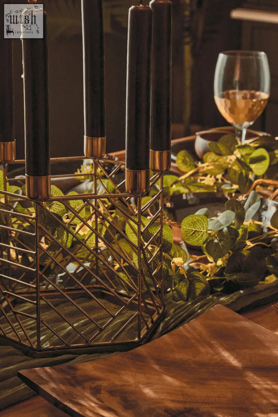 Black hexagonal candle holder with gold-toned metal accents and geometric wireframe design for candles