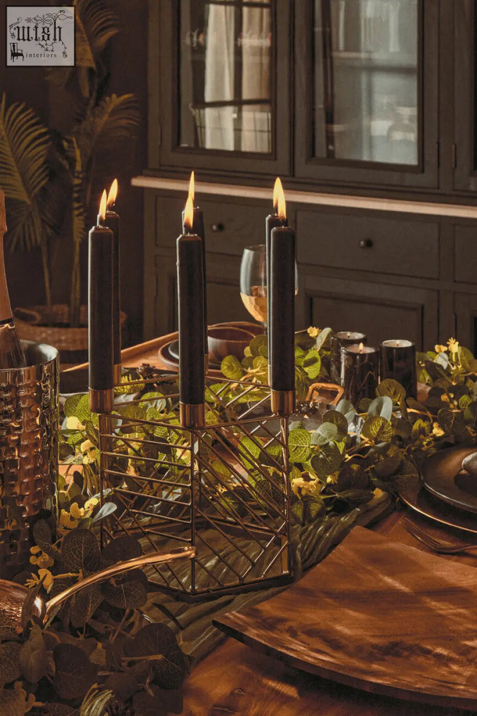 Black taper candles with gold bases in a gold geometric hexagonal candle holder for stylish decor