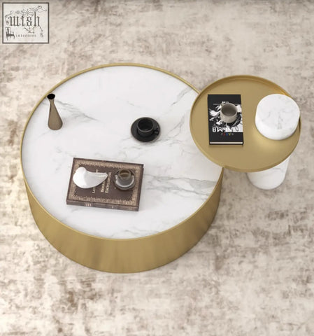 Gold-framed round marble coffee table with white marble top featuring gray veining from mason marble set