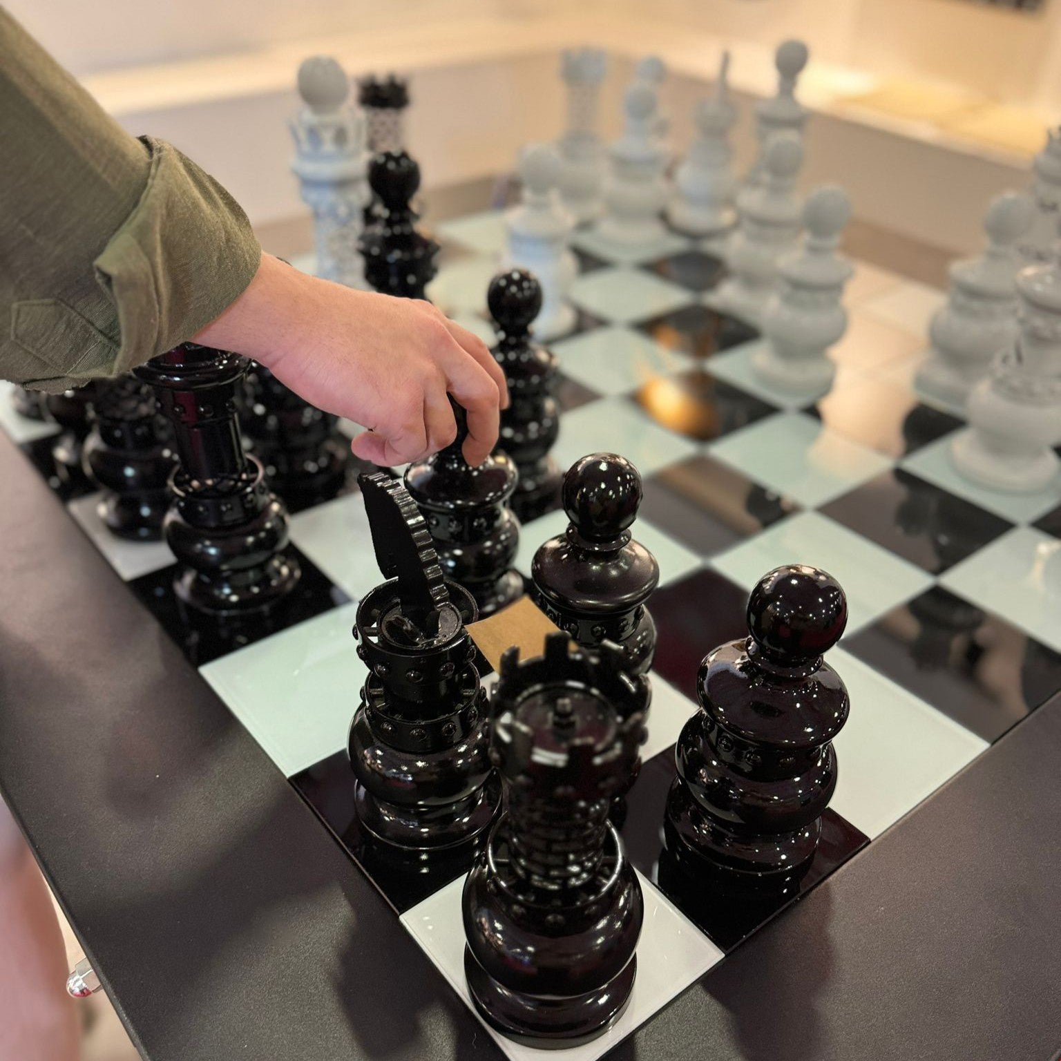 Glossy black chess pieces with a reflective finish on an archtwain masterpiece chess table checkerboard
