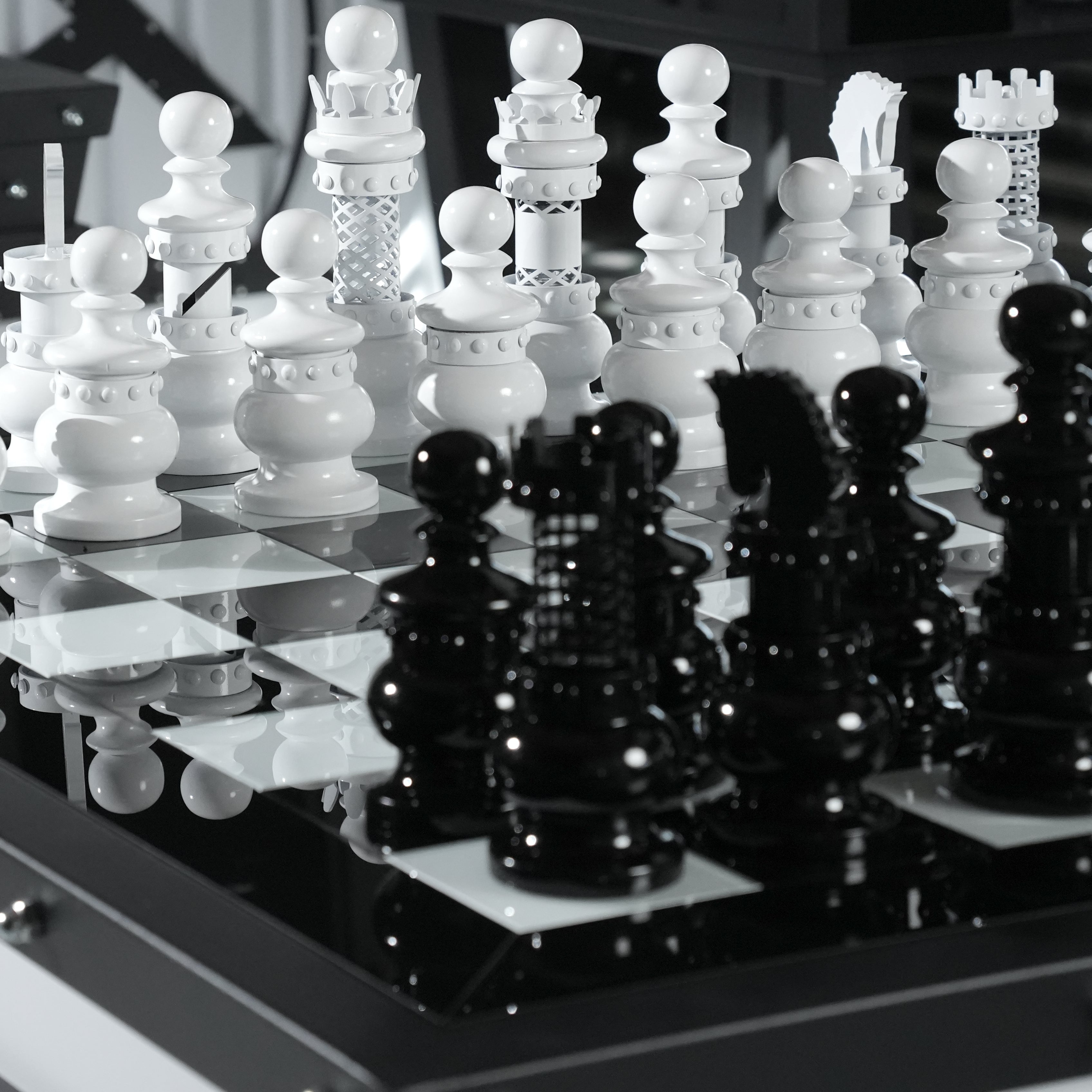 Glossy black and white ornate pieces on a reflective checkered board of the archtwain masterpiece chess table