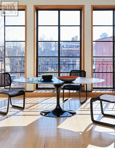 Black glossy pedestal dining table with sleek curved glass top perfect for elegant oval dining spaces