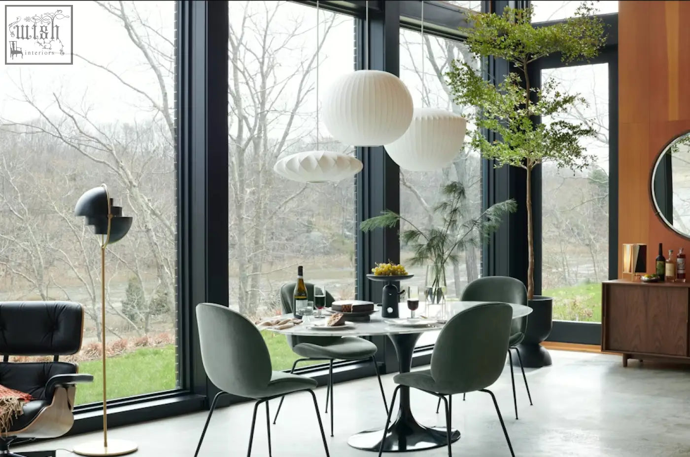 Modern white spherical pendant lights hang above the masuda oval dining table with marble top for stylish oval dining