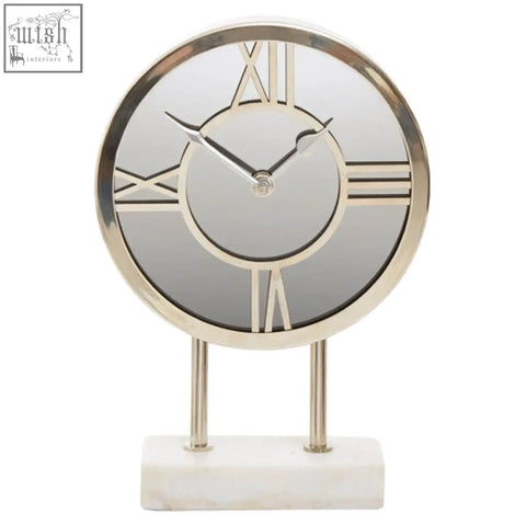 Silver-framed clock with roman numerals on white marble base features a sleek white marble base design