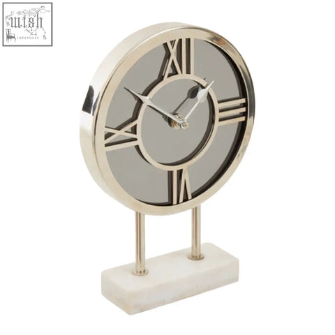Silver-toned clock with roman numerals and mirrored face on a white marble base for elegant decor with white marble base detail