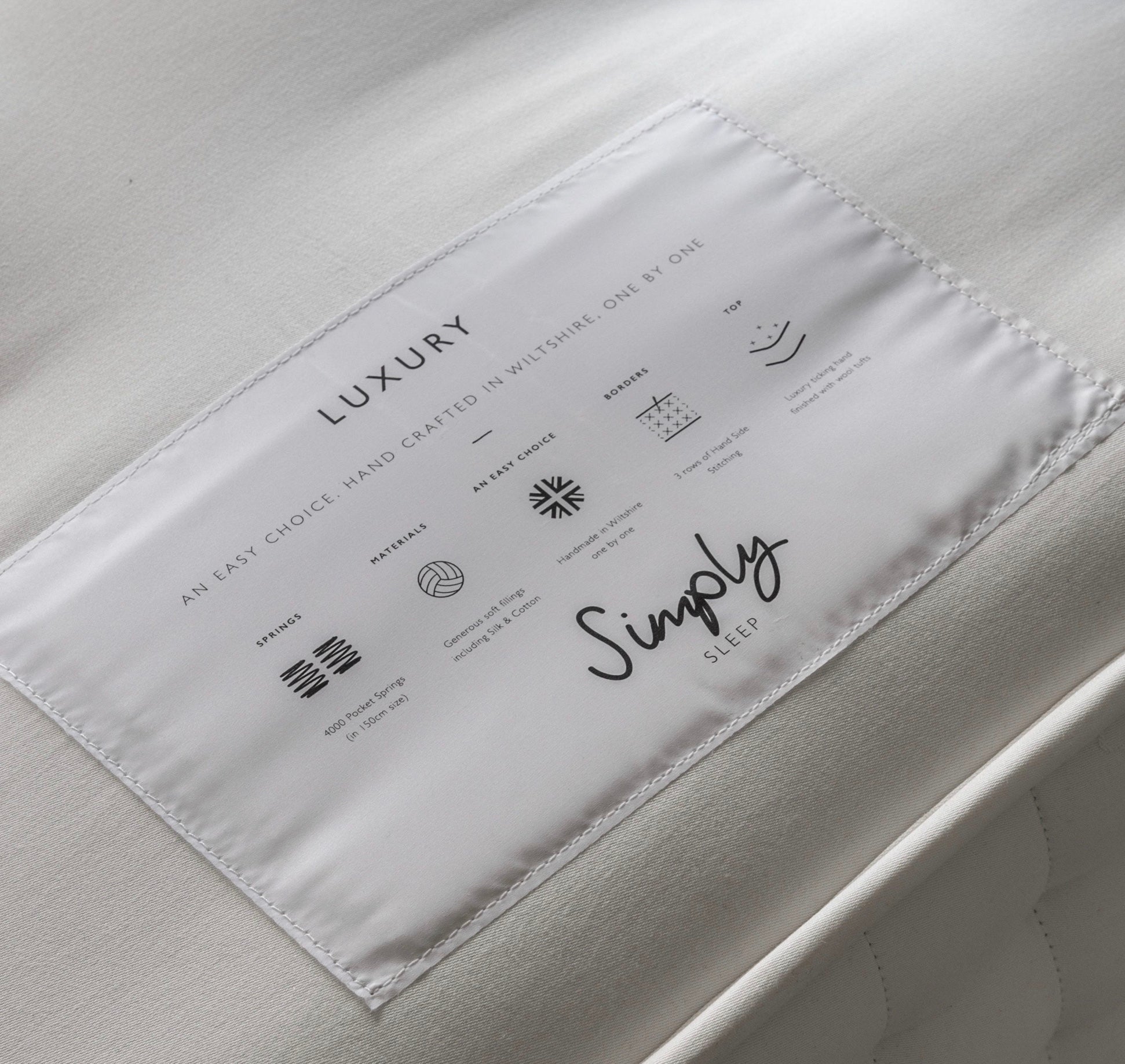 White embroidered label on luxury simply sleep mattress luxury 4000 springs highlighting item width and height details