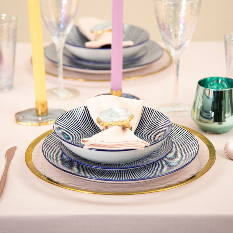 Blue and white striped ceramic bowl with gold rim on matching plate from maya 12 piece white dinner set