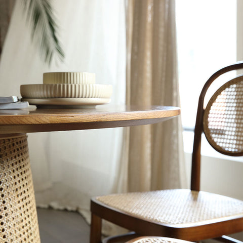 Beige ribbed ceramic stackable plates on a wooden table with the maya dining table rattan in the background