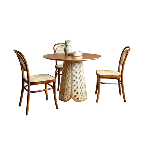 Round wooden maya dining table with woven cane base and matching rattan dining chairs for stylish dining