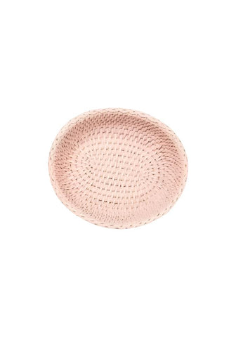 A delicate pink mayfair trinket hold all rattan basket with a subtle textured pattern and rounded edges