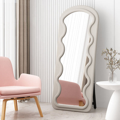 Melody full length mirror with a tall cream-colored frame featuring a wavy sculpted design for stylish decor