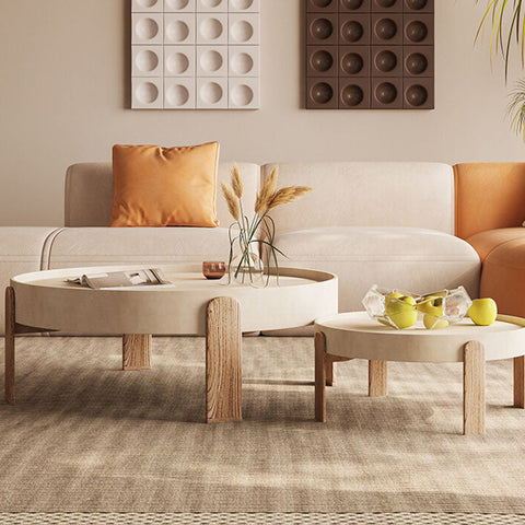 Cream-colored oval nesting coffee table with rustic wooden legs in merle nesting coffee set minimalist design