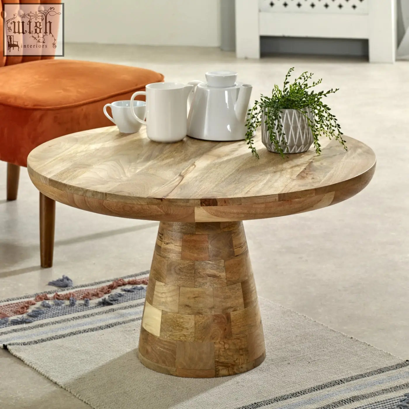 Merlin mango wooden round coffee table with natural finish and patchwork pedestal base in mushroom style