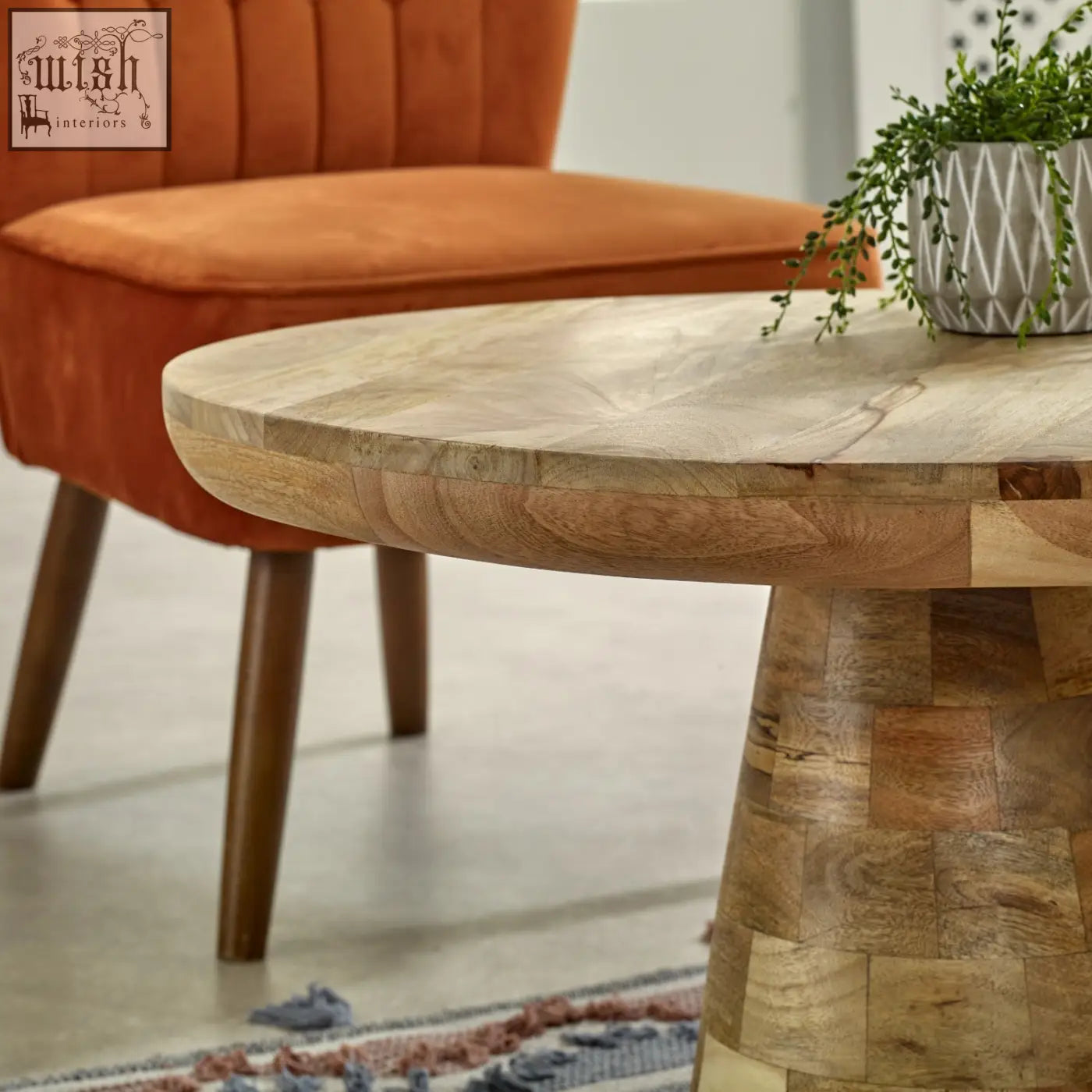 Merlin mango wooden round coffee table with a natural finish and stacked wood panel base in mushroom style