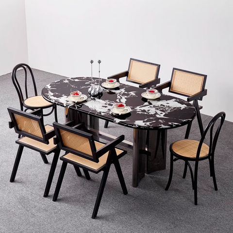 Black marble oval meroy dining table with six matching cane-backed chairs perfect for stylish dining spaces
