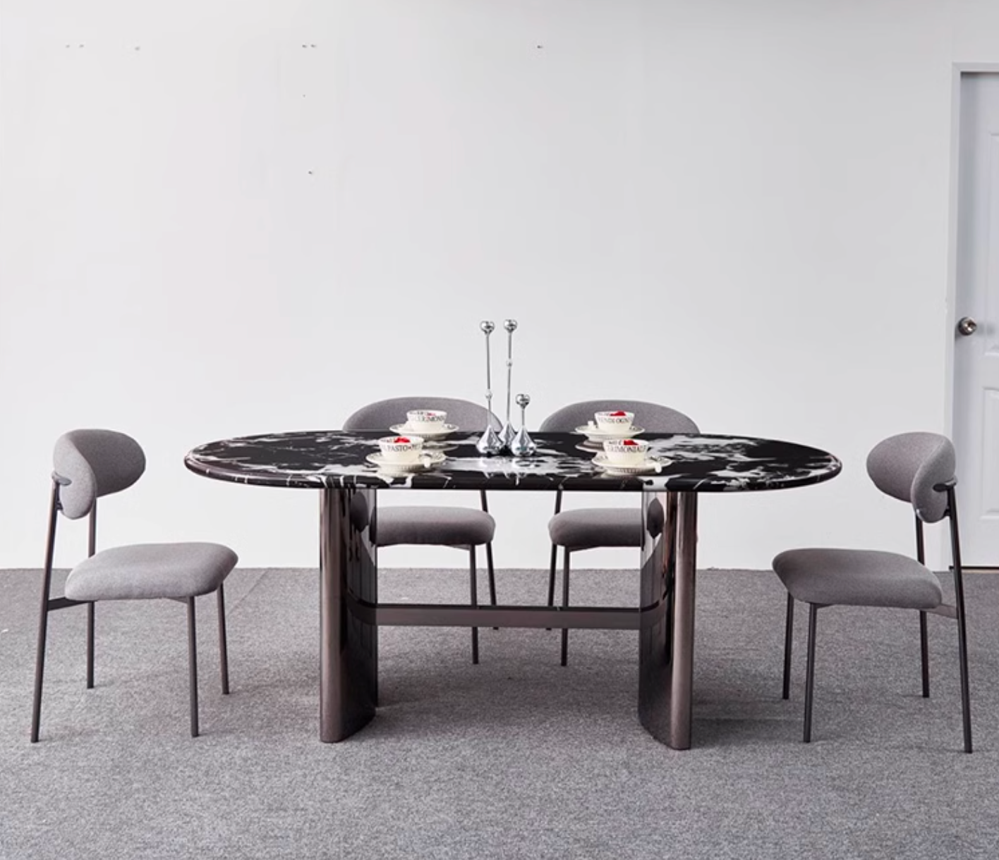 Black marble oval dining table with sleek dark metal legs and modern minimalist design meroy dining table