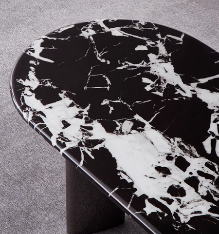 Black and white marble meroy dining table with a sleek oval top and minimalist pedestal base for modern dining