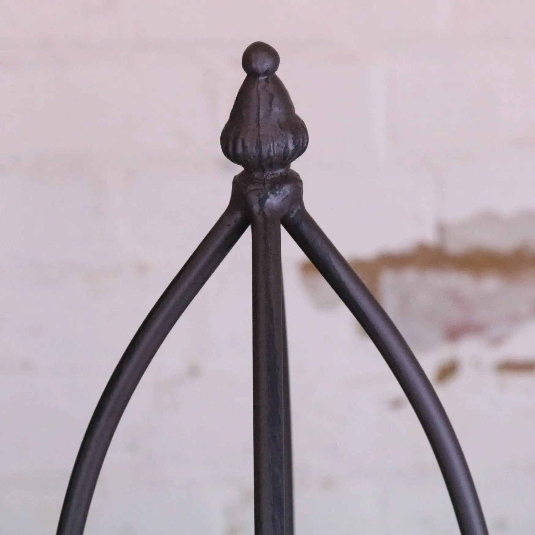 Dark wrought iron tripod stand with ornate rounded finial top for metal garden obelisks set of 3