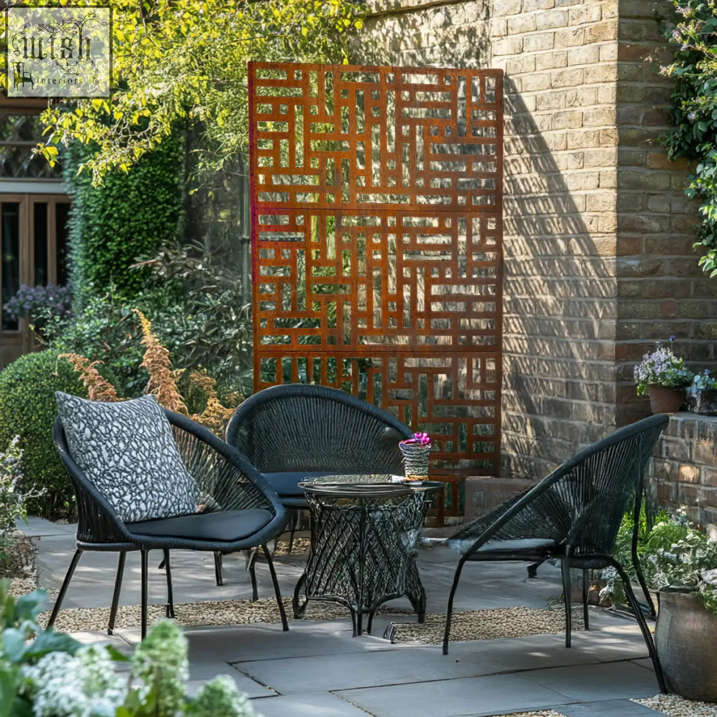 Black wicker patio set with rust-colored metal privacy screen featuring geometric maze pattern for indoor outdoor use