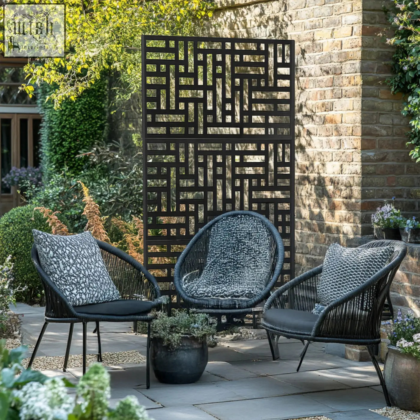 Black woven wicker patio chairs with cushions next to a black metal privacy screen 90cm x 180cm maze design