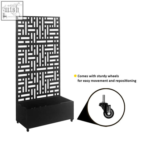 Black metal indoor outdoor privacy screen with geometric lattice top and wheeled base holding a planter