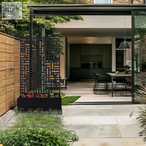 Black metal indoor outdoor privacy screen with geometric cutout pattern and matching planter filled with colorful flowers