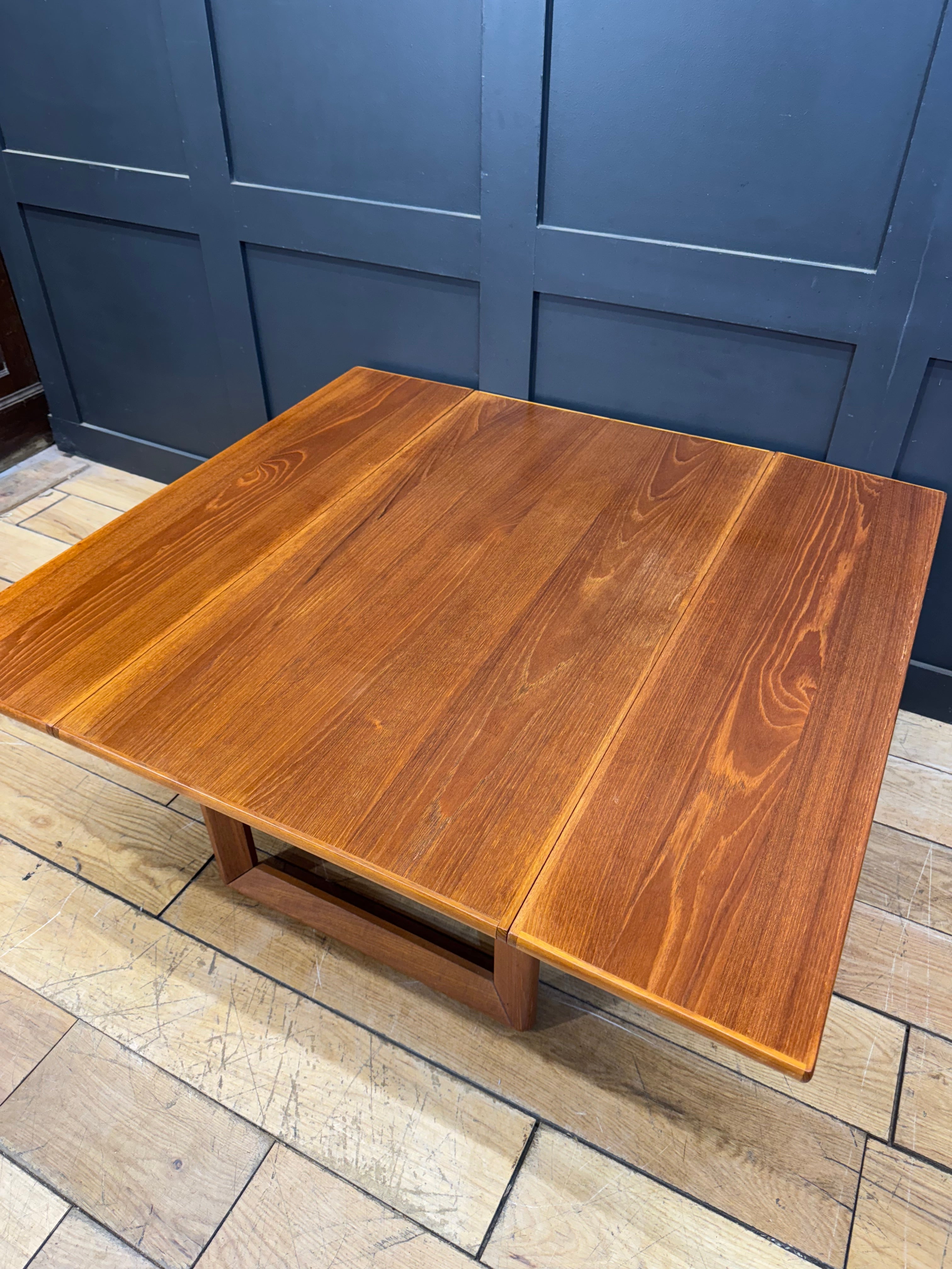 Mid century teak drop leaf coffee table with warm tones smooth polished finish and clean lines extendable design