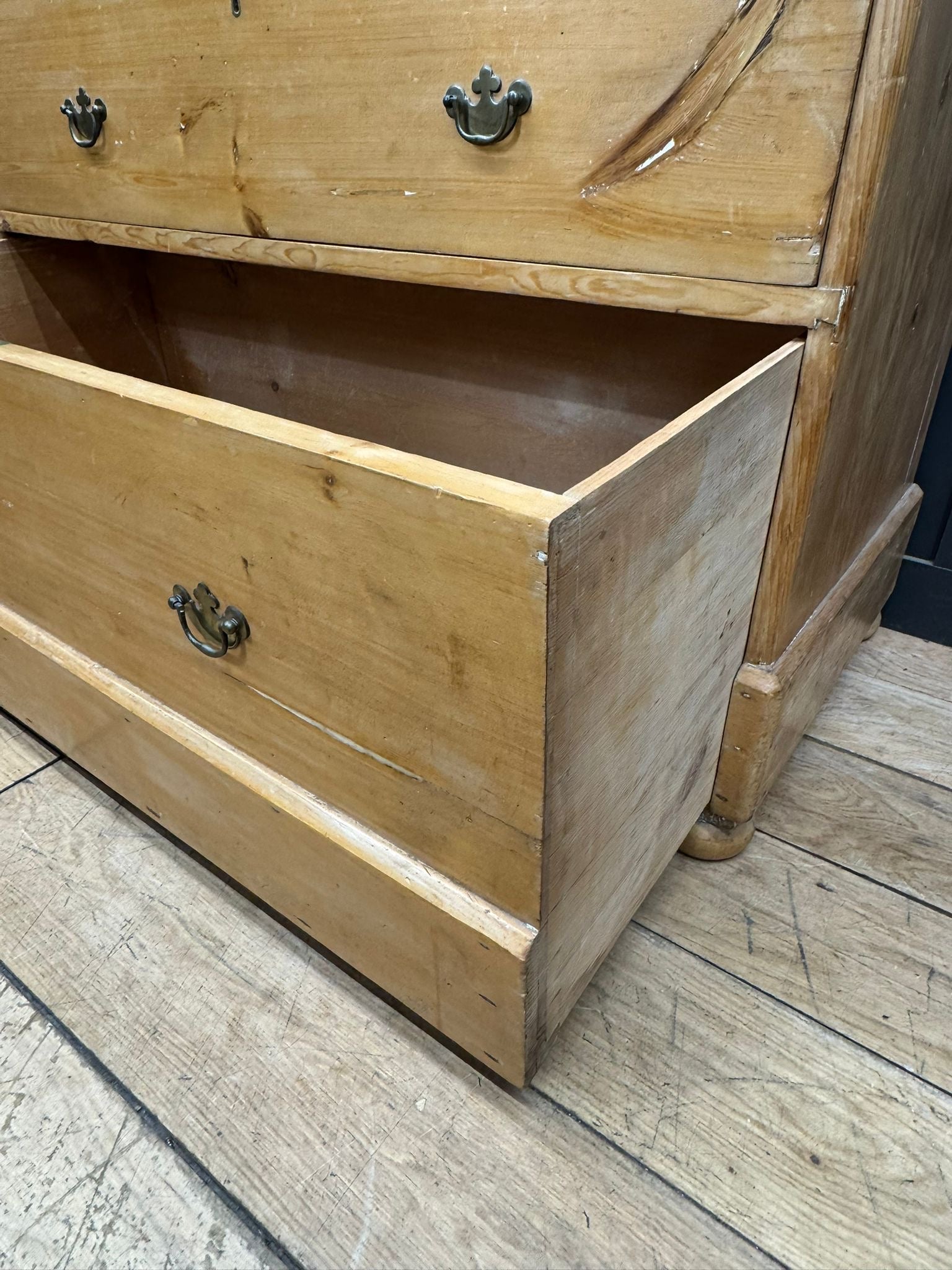 Light-colored pine chest of drawers with rounded corners metal handles and rustic finish for farmhouse bedroom storage