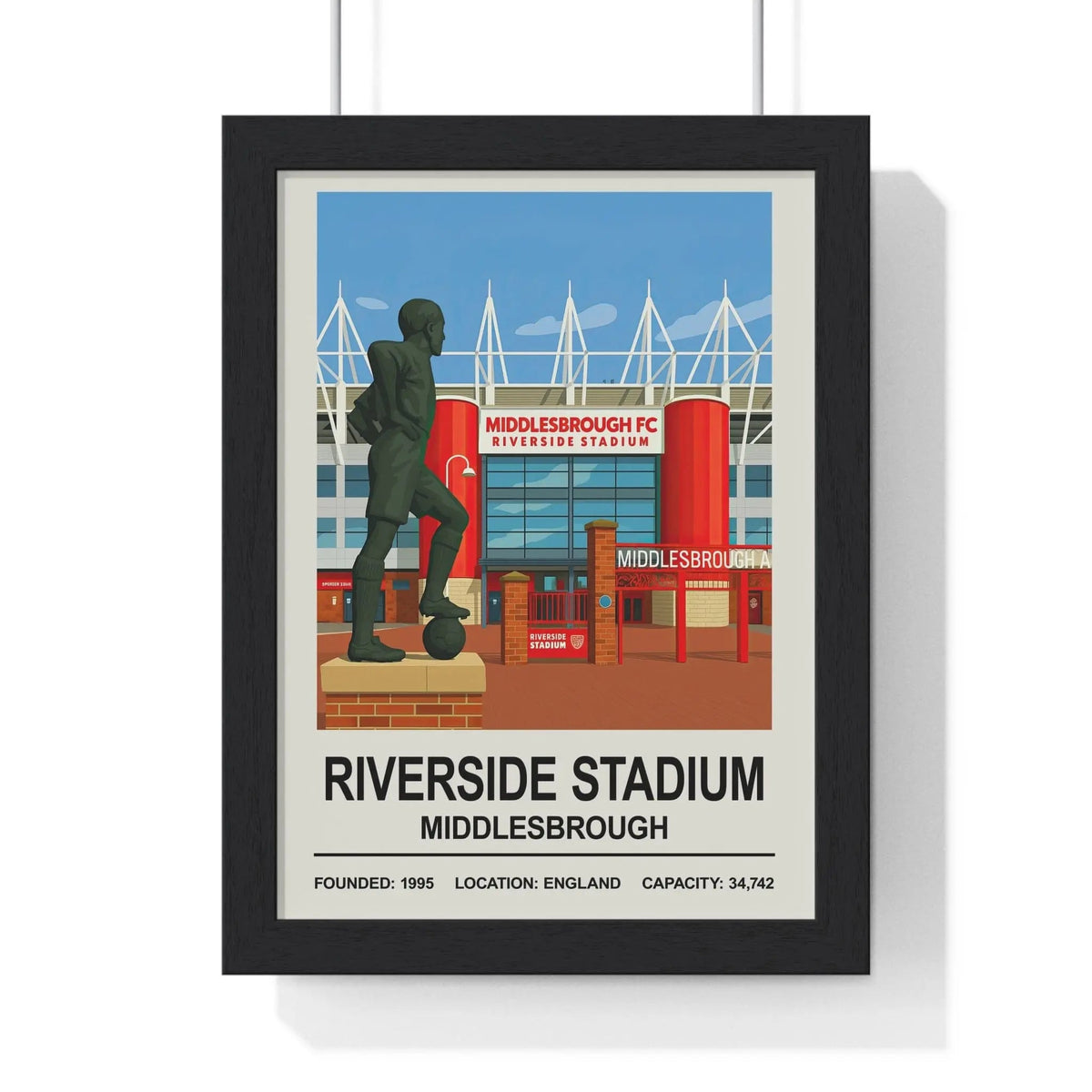Black-framed middlesbrough riverside stadium print featuring stylized red blue stadium and dark green statue in front