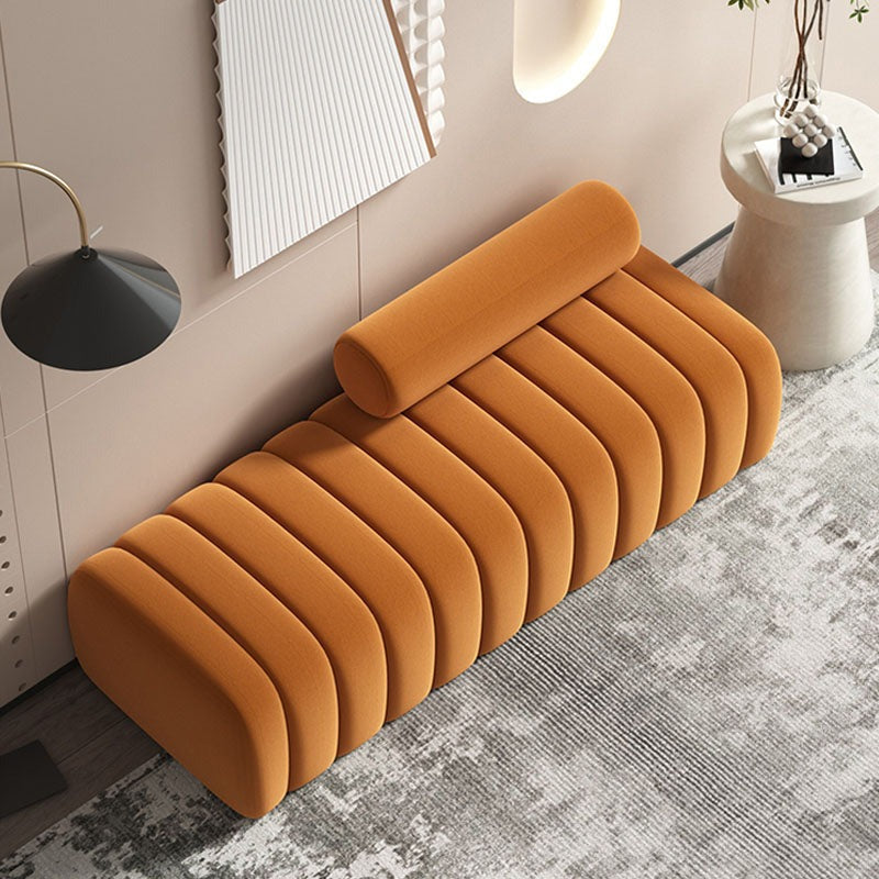 A plush mustard-yellow velvet mignon bread bench with ribbed design and attached cylindrical pillow for comfy seating