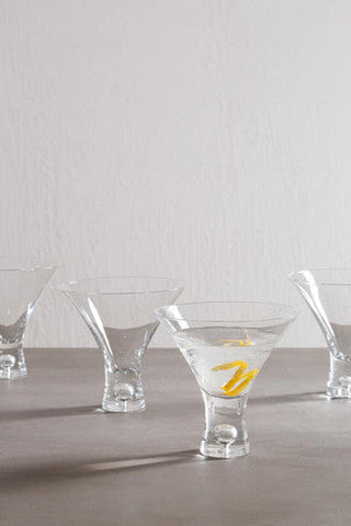 Mila set of 2 clear cocktail glasses 330ml with distinctive stems one glass contains ice and yellow citrus twists