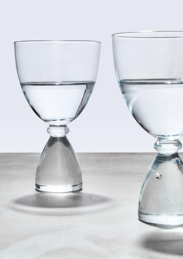 Mila set of 2 clear cocktail glasses with slender stems and hourglass-shaped base filled halfway with water