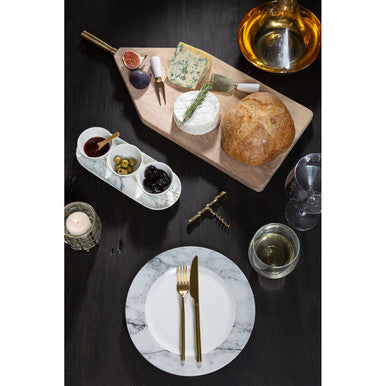 Wooden cheese board with gold-handled knife and assorted cheeses paired beside mila set glass tumblers with wide bowl design