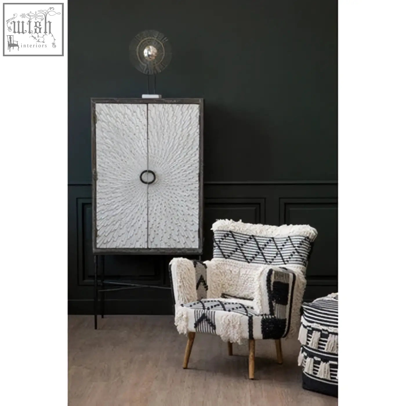Black and white patterned armchair with textured wool fabric next to a milan two door elm wood wine cabinet