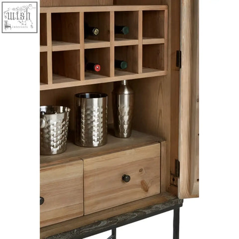 The milan two door elm wood wine cabinet has a rustic finish with metal accents and hammered silver cocktail shakers
