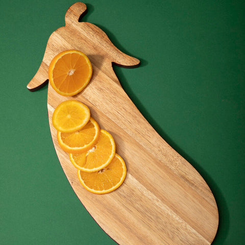 Light brown wooden chopping board shaped like a pepper with sliced oranges from mimo aubergine design chopping collection