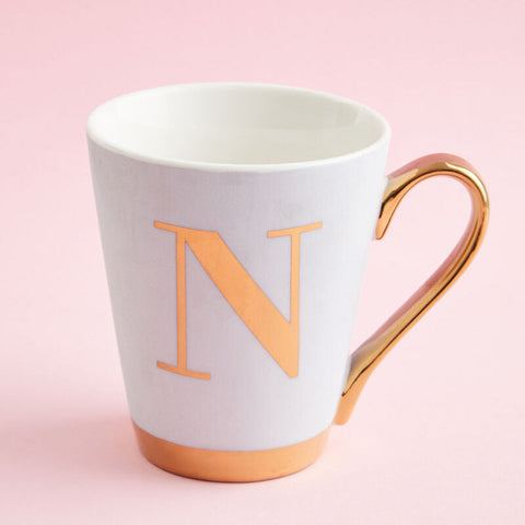 White ceramic mug with gold handle base and orange n letter in frosted deco style from mimo green frosted collection
