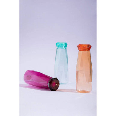 Three translucent mimo teal drinking water bottles with faceted design and colorful pink teal and peach caps on white surface