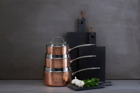 Stacked minerva copper finish large hammered saucepans with stainless steel rims and sleek silver handles