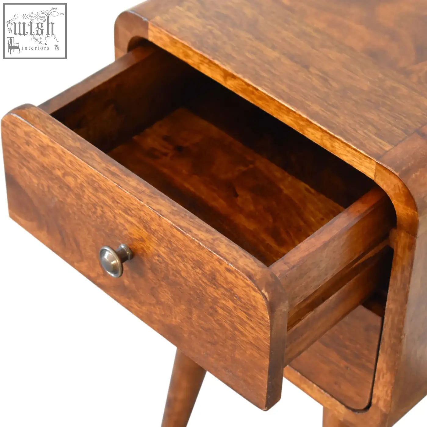 A warm brown curved bedside mini chestnut table made of solid mango wood with a metallic knob drawer front