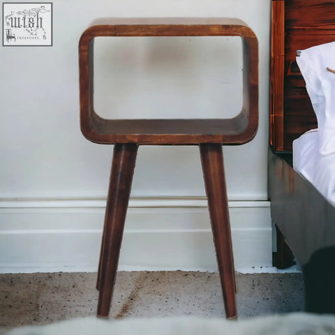 A sleek mini chestnut curved open bedside table made of wood with an open shelf and tapered legs