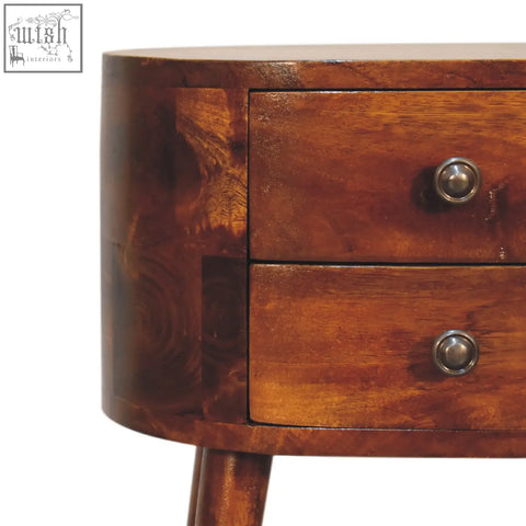 Rich warm-toned wooden mini chestnut rounded bedside table with two drawers and polished metal knobs