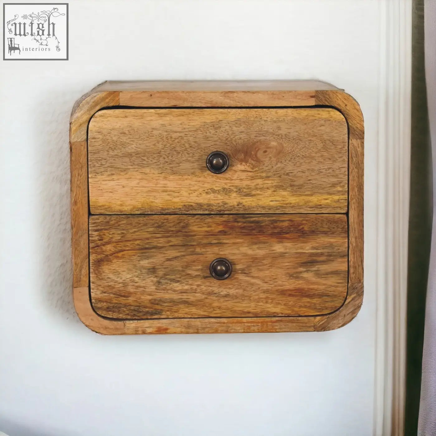 Rustic mini curve floating bedside table in solid mango wood with two drawers and dark metal knobs showing natural grain