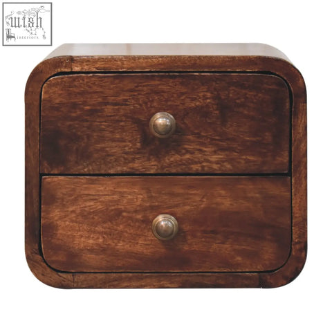 A dark brown california walnut mini curved wall mounted nightstand with two drawers and brass knobs