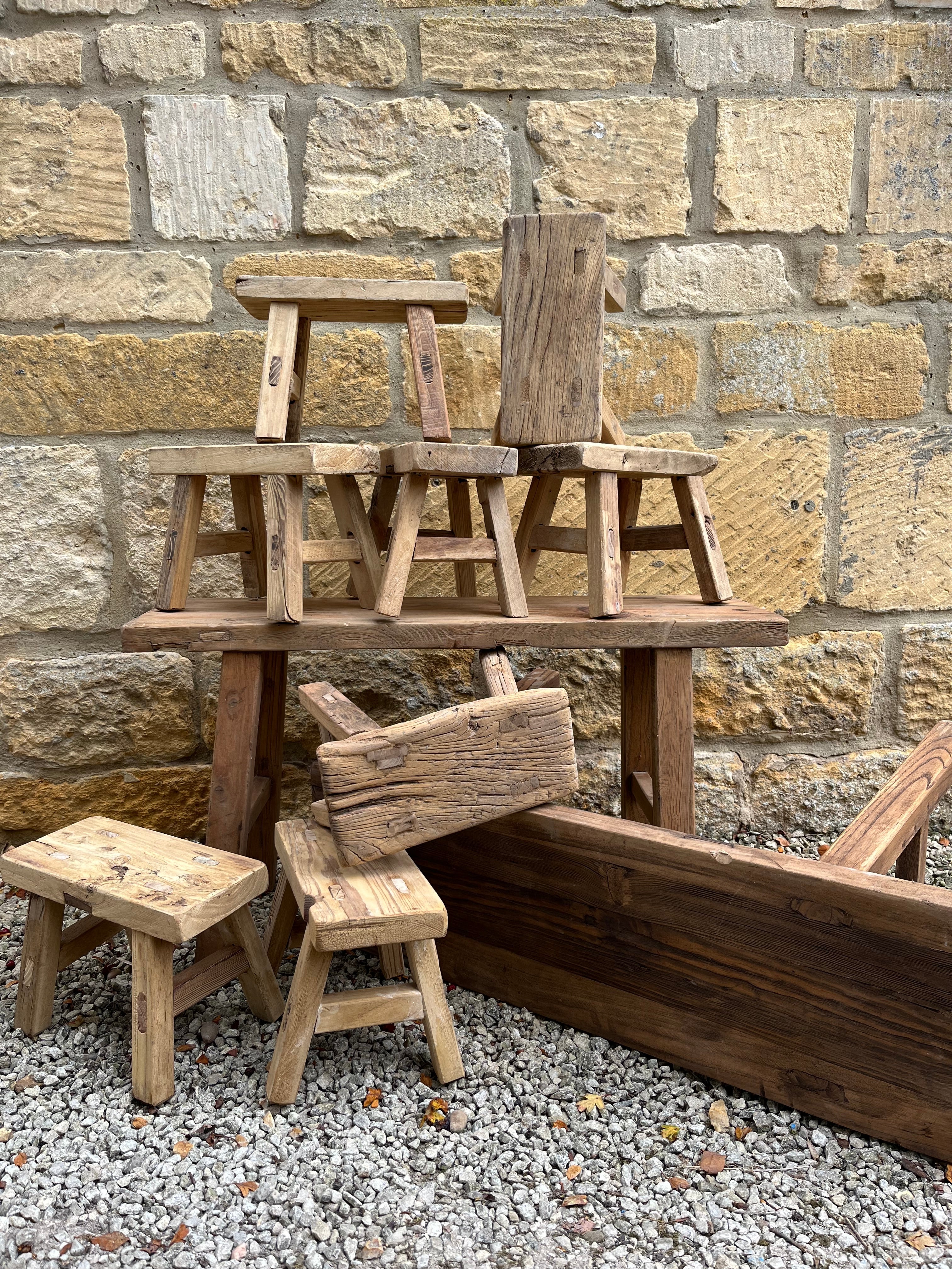 Rustic mini elm stools with weathered natural grain and varied brown tones in textured wooden material