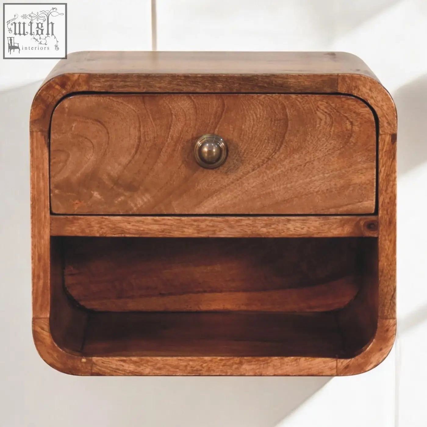 A warm honey caramel mango wood mini bedside with open slot wall mounted design and brass knob drawer
