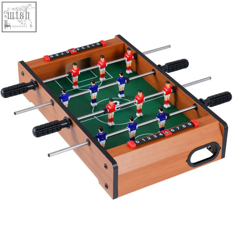 Wooden mini indoor foosball table with green field red and blue players metal rods black handles and scoring sliders