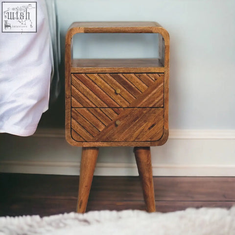 A mid-century modern mini lille curved bedside table in solid oak mango wood with two drawers and an open shelf