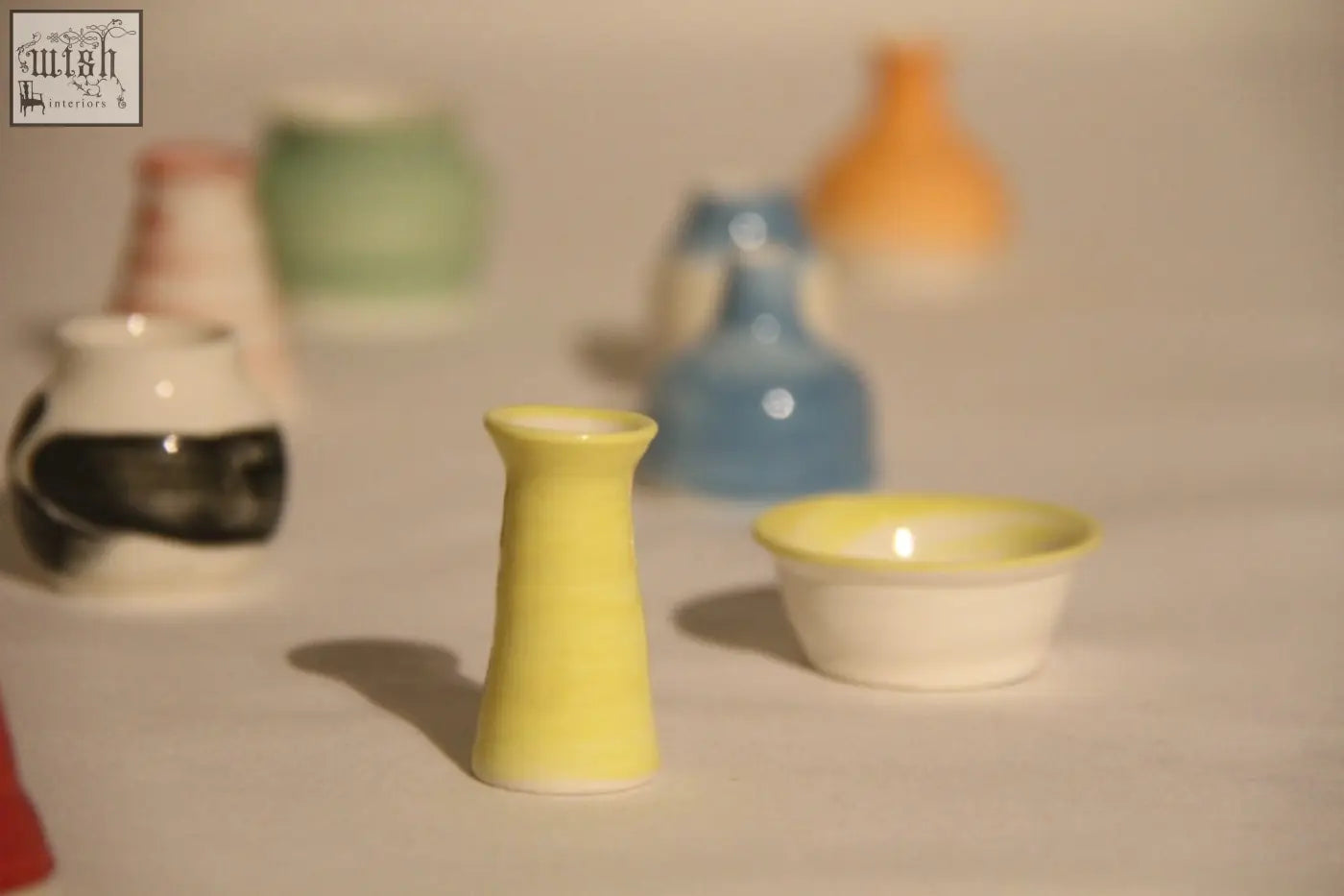 A slender glossy yellow ceramic mini pot with a flared rim and tapered body perfect for your mini pot mystery box