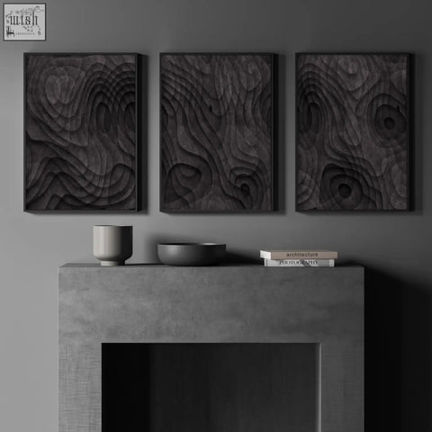 Three dark charcoal minimalist art prints with textured swirling patterns hang above a concrete fireplace mantel